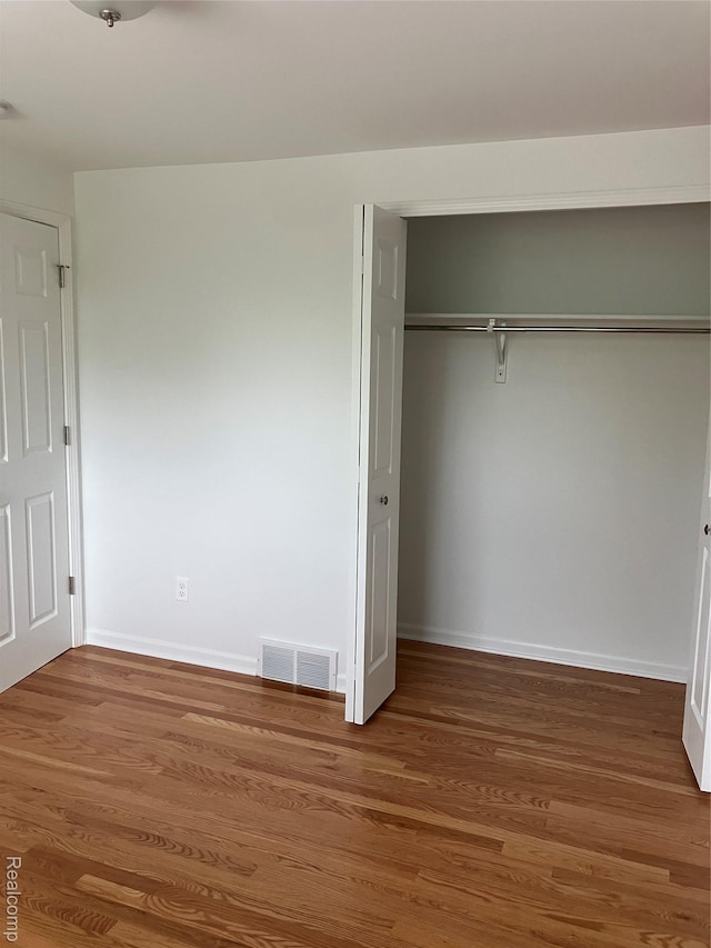 20747 Washington Dr, Roseville, MI 48066 - unfurnished bedroom with a closet, wood finished floors, and baseboards