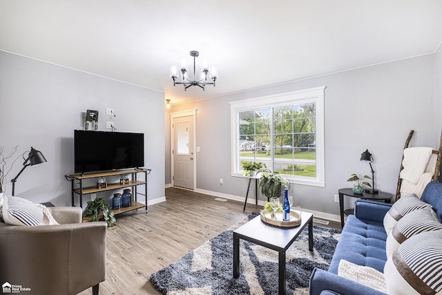 10207 Frances Rd, Flushing, MI 48433 - living area featuring a chandelier, light wood finished floors, and baseboards