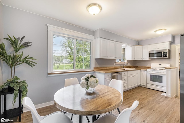 10207 Frances Rd, Flushing, MI 48433 - kitchen with stainless steel appliances, a sink, and white cabinetry