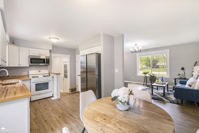10207 Frances Rd, Flushing, MI 48433 - dining space with light wood-style floors, a chandelier, and baseboards