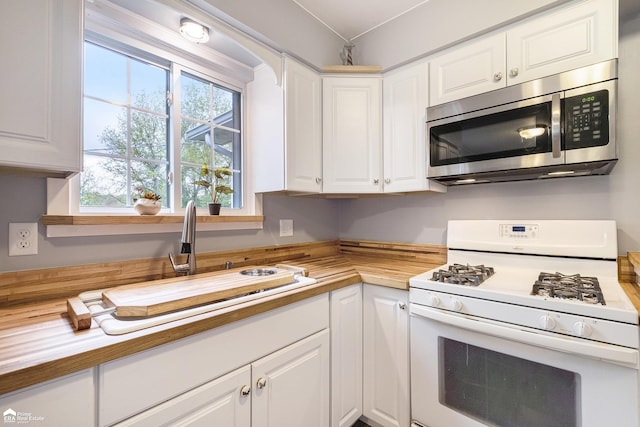 10207 Frances Rd, Flushing, MI 48433 - kitchen featuring white gas range oven, stainless steel microwave, white cabinets, and a sink
