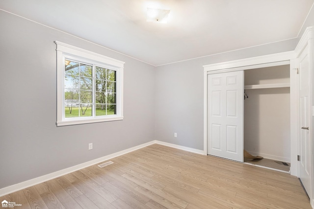 10207 Frances Rd, Flushing, MI 48433 - unfurnished bedroom featuring light wood finished floors, baseboards, and a closet
