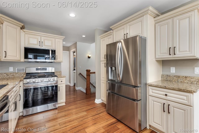 52657 Creekside Dr, Chesterfield, MI 48047 - kitchen with appliances with stainless steel finishes, cream cabinets, light wood-style floors, recessed lighting, and light stone countertops