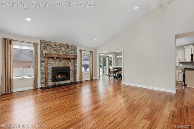 52657 Creekside Dr, Chesterfield, MI 48047 - unfurnished living room featuring light wood finished floors, high vaulted ceiling, a stone fireplace, and recessed lighting