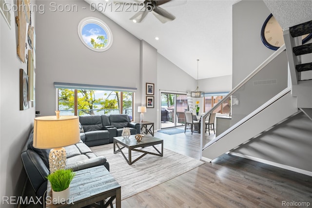 7457 Haviland Beach Dr, Argentine, MI 48451 - living area featuring high vaulted ceiling, plenty of natural light, stairs, ceiling fan, and wood finished floors