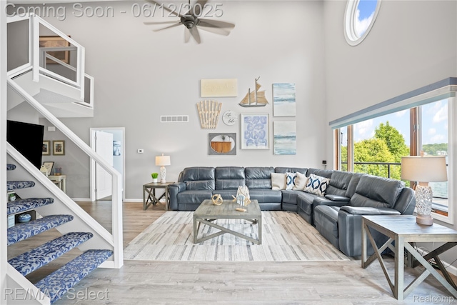 7457 Haviland Beach Dr, Argentine, MI 48451 - living area featuring a high ceiling, a ceiling fan, stairway, and wood finished floors