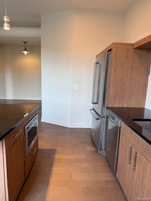 804 N Main St Unit 2A, Rochester, MI 48307 - kitchen featuring appliances with stainless steel finishes, wood finished floors, baseboards, and decorative light fixtures