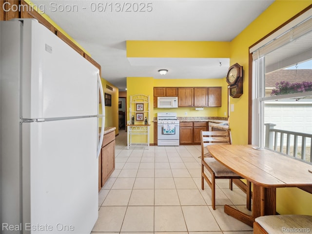 8907 Mccoll Side Rd, Brighton, MI 48116 - kitchen with white appliances, brown cabinets, light tile patterned floors, and light countertops
