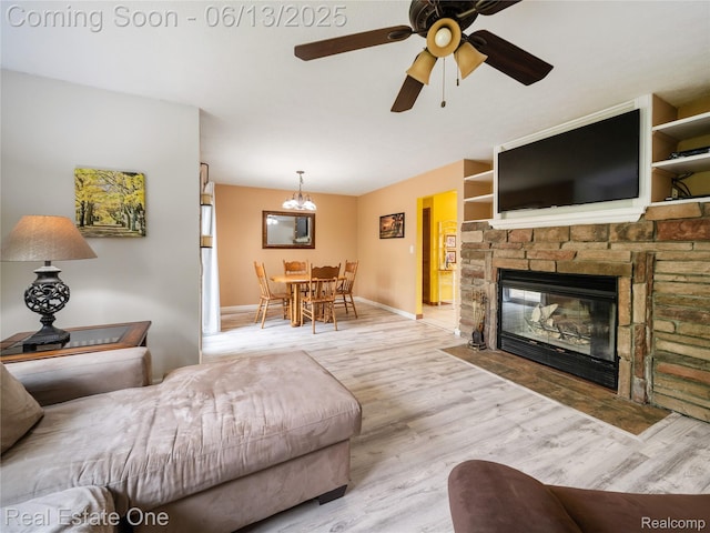 8907 Mccoll Side Rd, Brighton, MI 48116 - living area featuring wood finished floors, a ceiling fan, and a stone fireplace