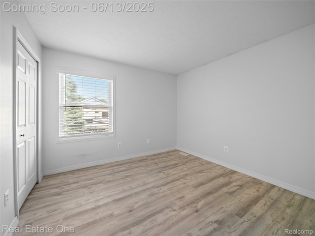 8907 Mccoll Side Rd, Brighton, MI 48116 - unfurnished bedroom featuring light wood-style floors and a closet