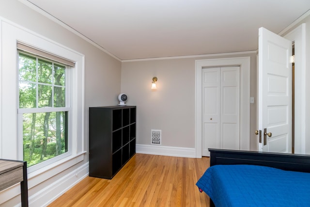 2430 Geddes Ave, Ann Arbor, MI 48104 - bedroom with light wood-style floors, baseboards, crown molding, and a closet