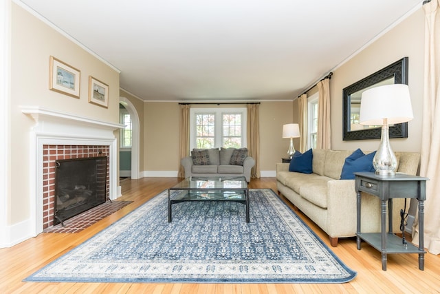 2430 Geddes Ave, Ann Arbor, MI 48104 - living room with hardwood / wood-style flooring, ornamental molding, arched walkways, a fireplace, and baseboards