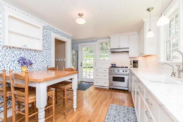 2430 Geddes Ave, Ann Arbor, MI 48104 - kitchen with high end stainless steel range, under cabinet range hood, a sink, wallpapered walls, and white cabinets