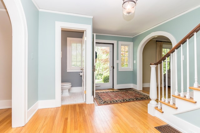 2430 Geddes Ave, Ann Arbor, MI 48104 - foyer featuring arched walkways, hardwood / wood-style flooring, baseboards, ornamental molding, and stairs