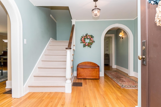 2430 Geddes Ave, Ann Arbor, MI 48104 - foyer entrance featuring hardwood / wood-style flooring, arched walkways, stairway, and crown molding