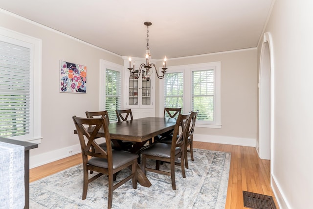 2430 Geddes Ave, Ann Arbor, MI 48104 - dining space featuring a chandelier, ornamental molding, light wood-style floors, and baseboards
