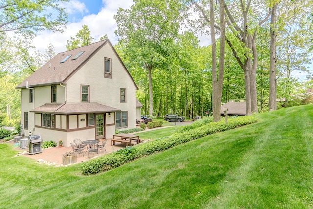 2430 Geddes Ave, Ann Arbor, MI 48104 - back of property featuring stucco siding, a patio area, a yard, and a shingled roof