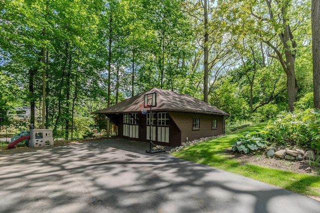 2430 Geddes Ave, Ann Arbor, MI 48104 - view of front facade with an outdoor structure, view of scattered trees, and asphalt driveway