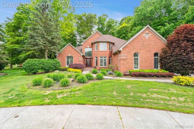 50565 Otter Creek Dr, Shelby Twp, MI 48317 - traditional-style house with brick siding and a front yard