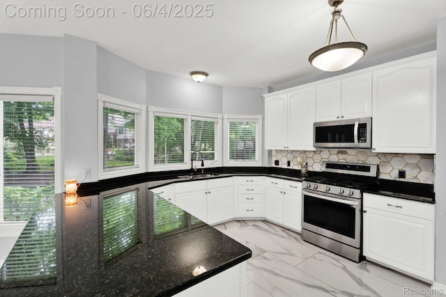 50565 Otter Creek Dr, Shelby Twp, MI 48317 - kitchen featuring appliances with stainless steel finishes, a sink, light marble finish flooring, and plenty of natural light