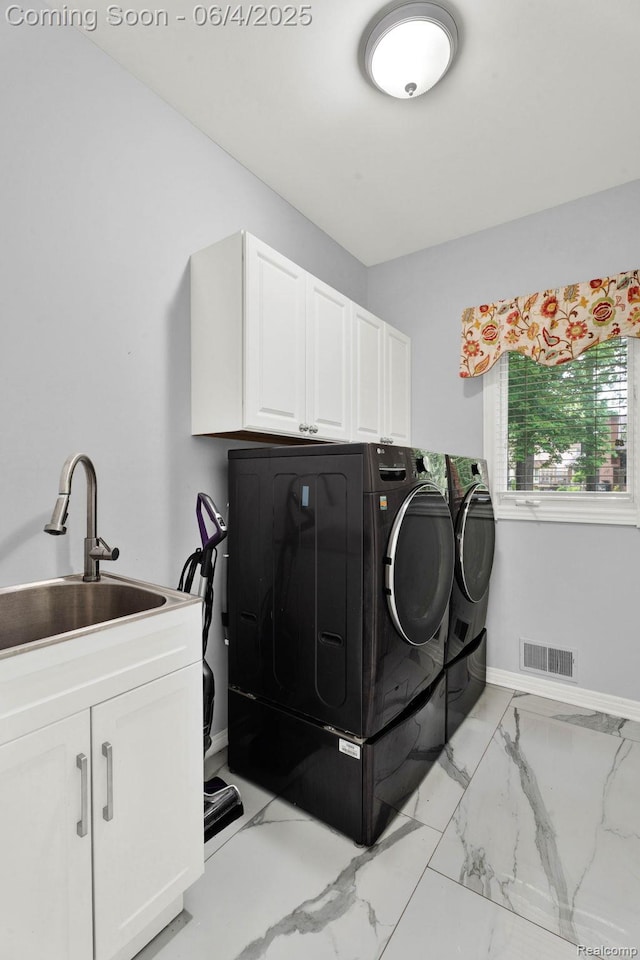 50565 Otter Creek Dr, Shelby Twp, MI 48317 - laundry room featuring separate washer and dryer, cabinet space, light marble finish flooring, and baseboards