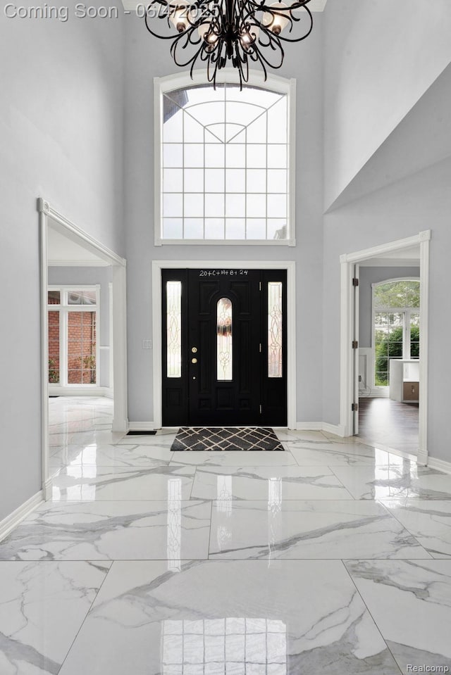 50565 Otter Creek Dr, Shelby Twp, MI 48317 - foyer featuring marble tiled floors, a chandelier, a high ceiling, and baseboards