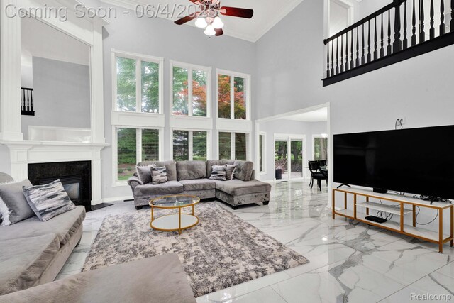 50565 Otter Creek Dr, Shelby Twp, MI 48317 - living room with a high ceiling, marble tiled floors, crown molding, a ceiling fan, and a premium fireplace