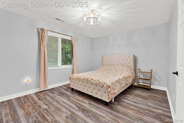50565 Otter Creek Dr, Shelby Twp, MI 48317 - bedroom with wood finished floors, a chandelier, and baseboards