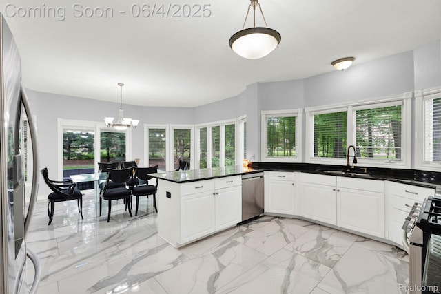 50565 Otter Creek Dr, Shelby Twp, MI 48317 - kitchen featuring a sink, appliances with stainless steel finishes, dark countertops, a chandelier, and light marble finish floors