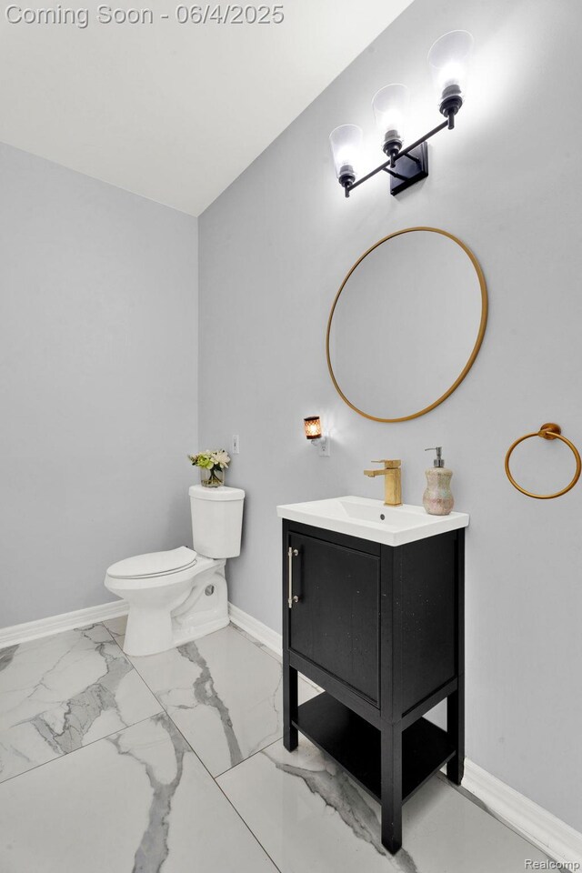 50565 Otter Creek Dr, Shelby Twp, MI 48317 - half bathroom with baseboards, vanity, marble finish floors, and toilet