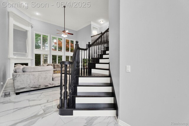 50565 Otter Creek Dr, Shelby Twp, MI 48317 - stairway with ornamental molding, a ceiling fan, marble finish floors, baseboards, and a fireplace