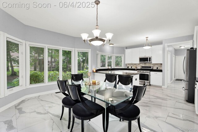 50565 Otter Creek Dr, Shelby Twp, MI 48317 - dining area featuring light marble finish floors, a chandelier, and baseboards