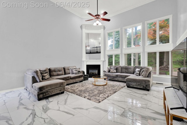 50565 Otter Creek Dr, Shelby Twp, MI 48317 - living room with ceiling fan, ornamental molding, a towering ceiling, a fireplace, and marble finish flooring