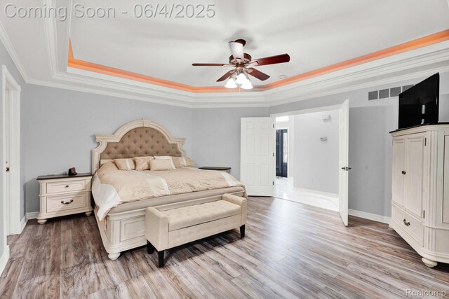 50565 Otter Creek Dr, Shelby Twp, MI 48317 - bedroom featuring a tray ceiling, wood finished floors, crown molding, baseboards, and a ceiling fan