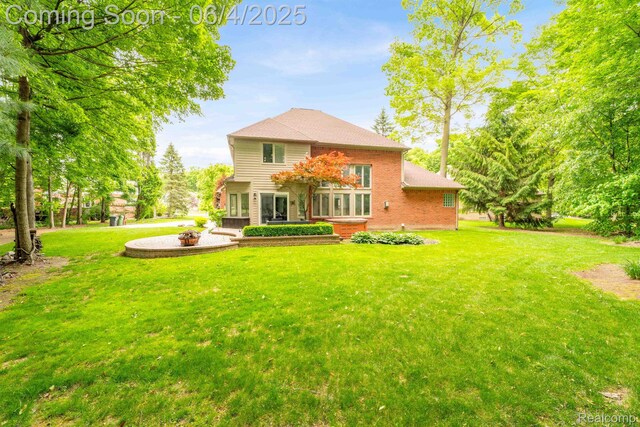 50565 Otter Creek Dr, Shelby Twp, MI 48317 - back of house featuring brick siding and a yard