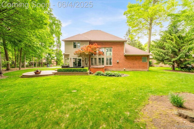 50565 Otter Creek Dr, Shelby Twp, MI 48317 - back of property featuring a hot tub, brick siding, a yard, and roof with shingles
