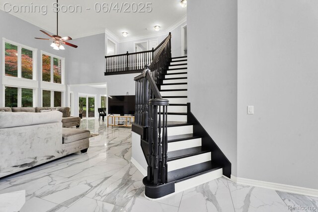 50565 Otter Creek Dr, Shelby Twp, MI 48317 - staircase with marble tiled flooring, crown molding, a ceiling fan, baseboards, and a towering ceiling