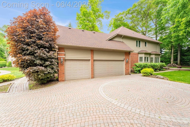50565 Otter Creek Dr, Shelby Twp, MI 48317 - view of front of property featuring brick siding, an attached garage, curved driveway, and roof with shingles