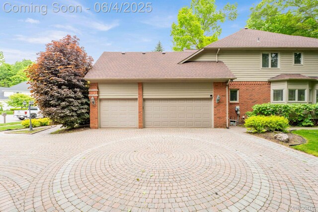 50565 Otter Creek Dr, Shelby Twp, MI 48317 - view of front of home with brick siding, a garage, curved driveway, and a shingled roof