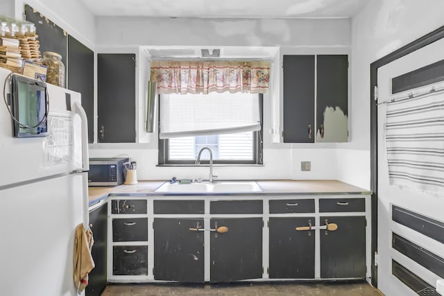 707 Glenwood Ave, Port Huron, MI 48060 - kitchen with freestanding refrigerator, a sink, dishwashing machine, stainless steel microwave, and light countertops
