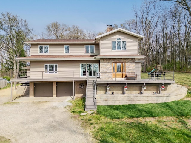 175 Templar Ave, Pinckney, MI 48169 - back of property with a garage, a chimney, dirt driveway, a wooden deck, and stone siding