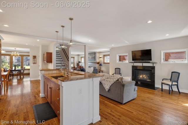 797 Washington Rd, Grosse Pointe, MI 48230 - kitchen featuring open floor plan, a glass covered fireplace, a sink, light wood-style floors, and recessed lighting