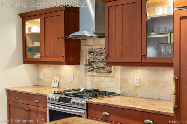 797 Washington Rd, Grosse Pointe, MI 48230 - kitchen with wall chimney range hood, gas range, tasteful backsplash, glass insert cabinets, and light stone countertops