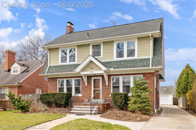797 Washington Rd, Grosse Pointe, MI 48230 - view of front facade with brick siding, a chimney, an outbuilding, and a detached garage