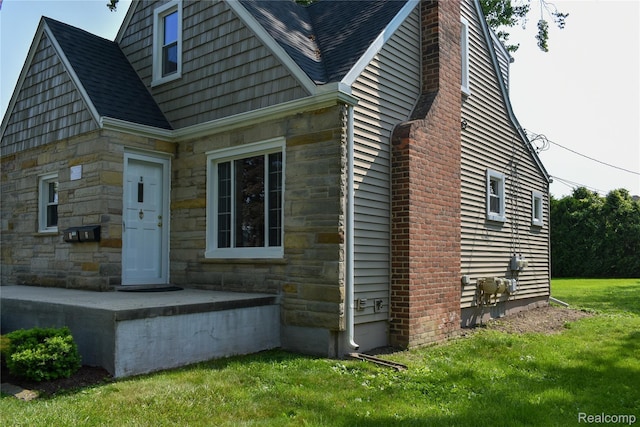 3434 Durham Rd, Clawson, MI 48073 - view of home's exterior featuring stone siding, a yard, roof with shingles, and a chimney