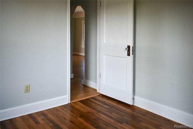 3434 Durham Rd, Clawson, MI 48073 - spare room featuring arched walkways, dark wood-type flooring, and baseboards