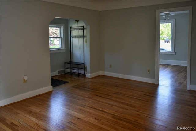 3434 Durham Rd, Clawson, MI 48073 - spare room with arched walkways, healthy amount of natural light, and hardwood / wood-style floors