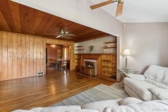 1250 W Thompson Rd, Fenton, MI 48430 - living area featuring a ceiling fan, wood finished floors, wooden walls, wood ceiling, and a fireplace