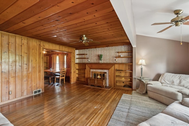 1250 W Thompson Rd, Fenton, MI 48430 - living room featuring a ceiling fan, wood walls, hardwood / wood-style floors, a glass covered fireplace, and wooden ceiling