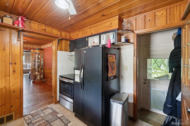 1250 W Thompson Rd, Fenton, MI 48430 - kitchen featuring black fridge, stainless steel range with electric cooktop, wood walls, a ceiling fan, and wood ceiling